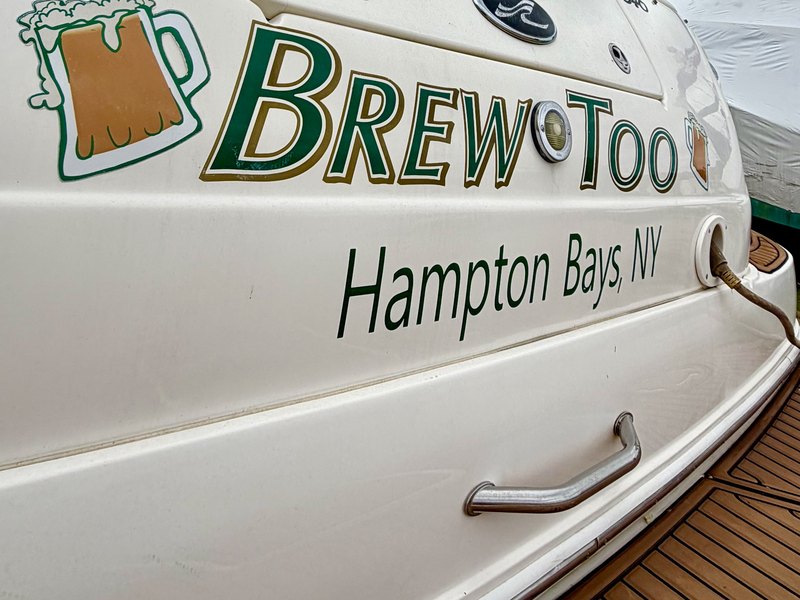 Green and gold boat lettering reading Brew Too with a beer mug graphic and Hampton Bays NY hailing port